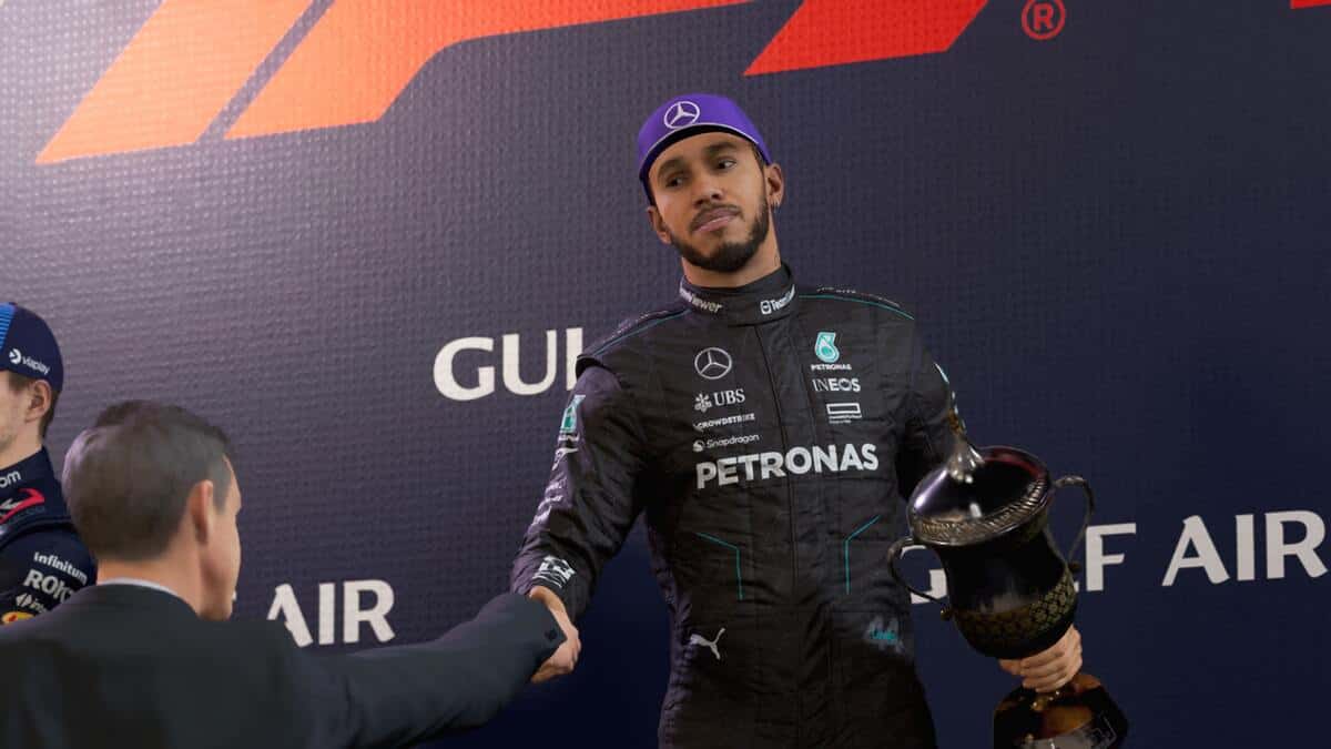 F1 24 preview: Lewis Hamilton holding a trophy and shaking a man's hand.