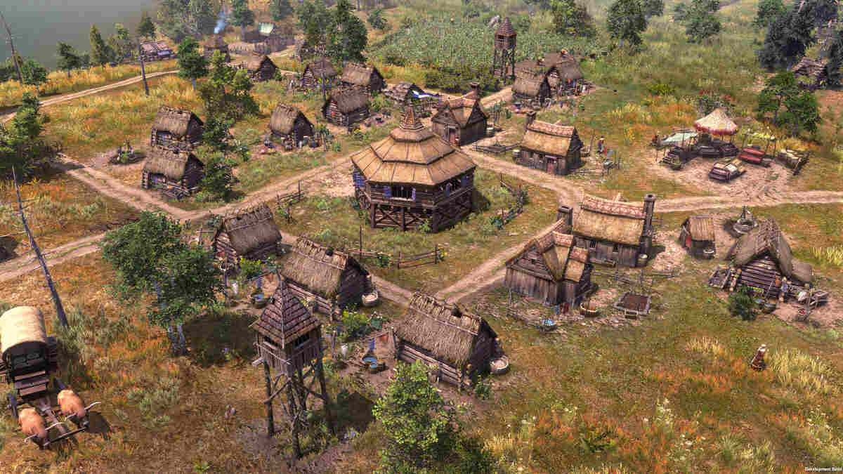 An overhead view of a detailed medieval village with numerous thatched-roof buildings in Farthest Frontier