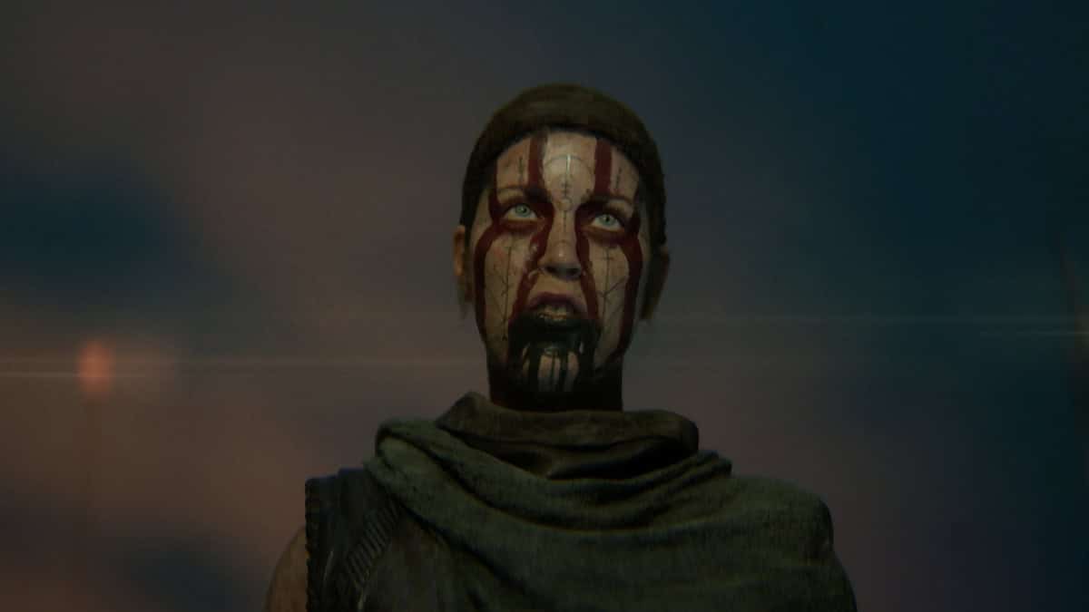 Hellblade 2 review: Senua with red paint on her face, looking fierce.