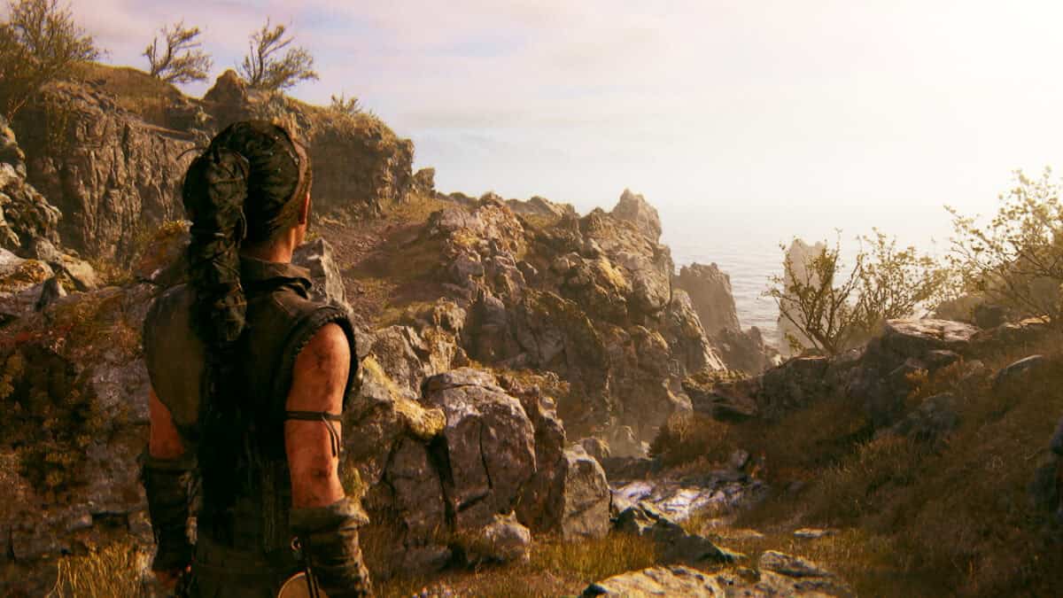 Hellblade 2 review: character Senua standing overlooking the sea on a rocky coastline.