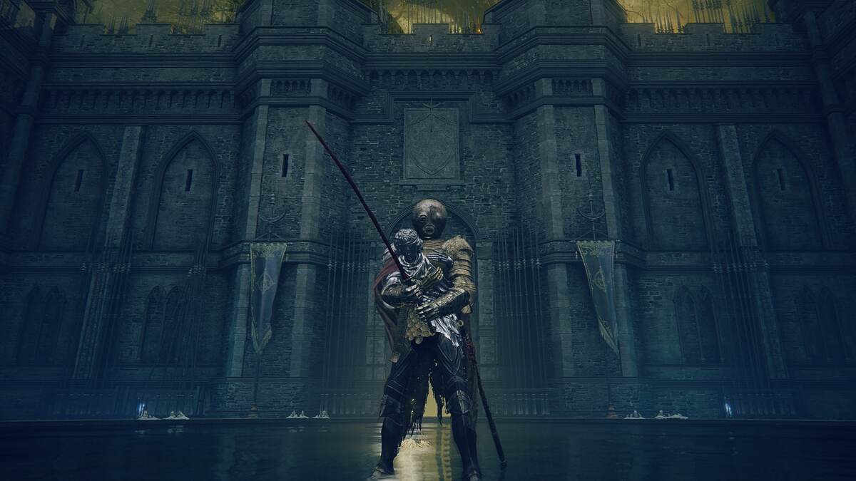 Shadow of Erdtree Remembrances: A player standing in a castle in shallow water in front of a large stone wall.