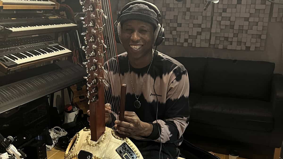 A person wearing headphones next to a Kora instrument.